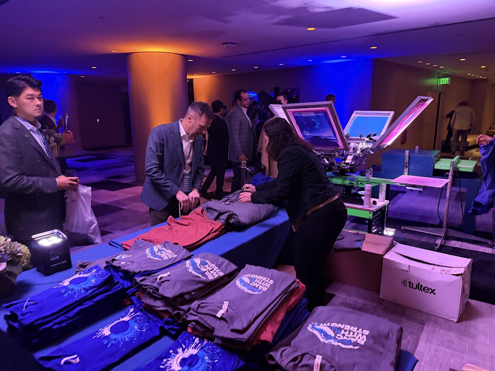 Merch table set for an executive summit with folded custom apparel
